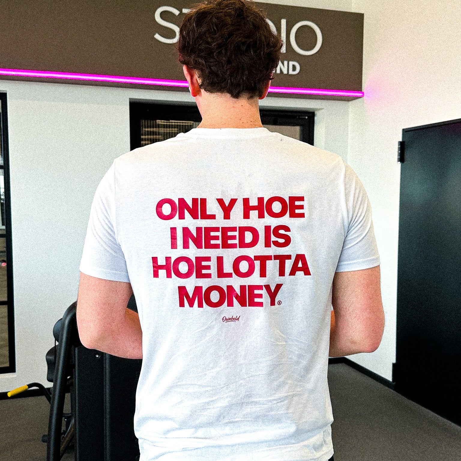Person wearing a white t-shirt with red text in an indoor setting