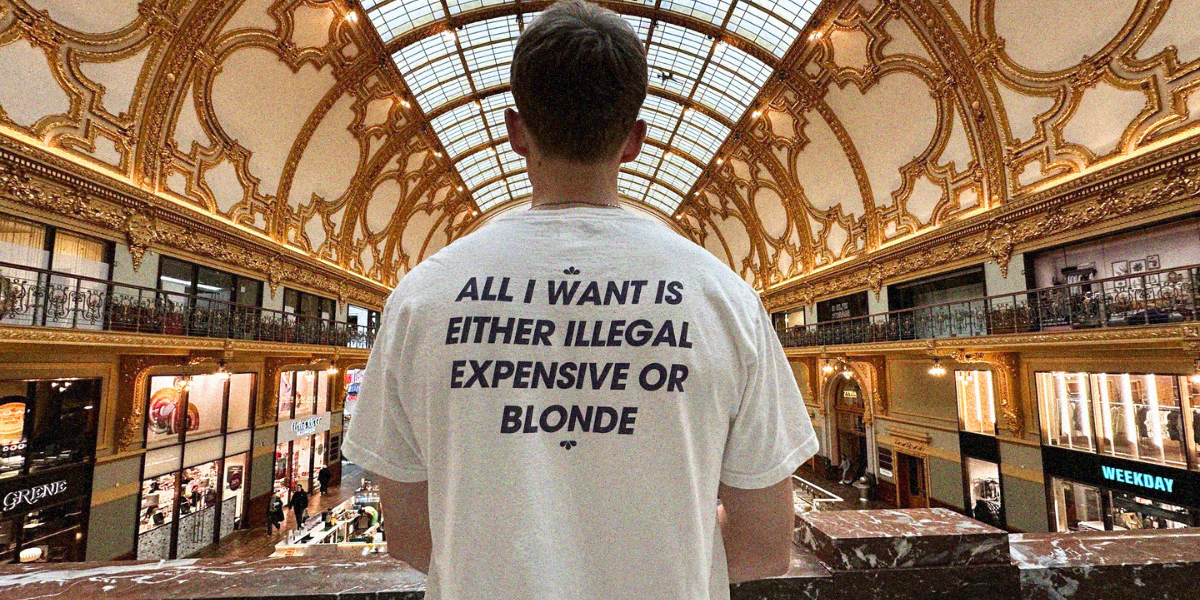 Person wearing a white t-shirt with text in a grand architectural setting