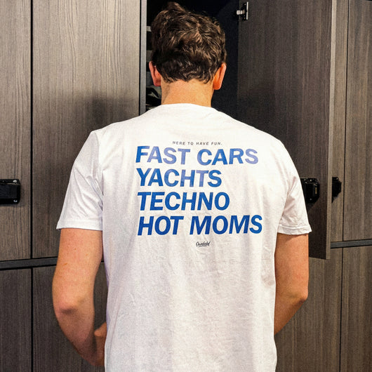 Person wearing a white t-shirt with text on the back in a locker room.