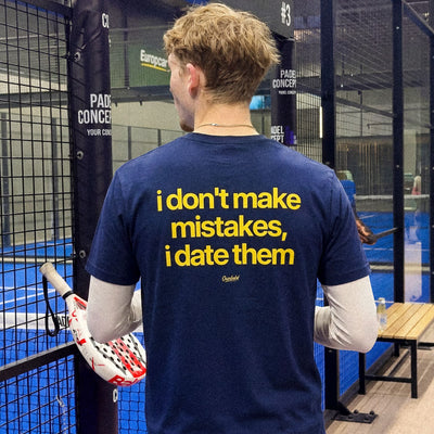 Person wearing a blue t-shirt with humorous text in an indoor sports facility.
